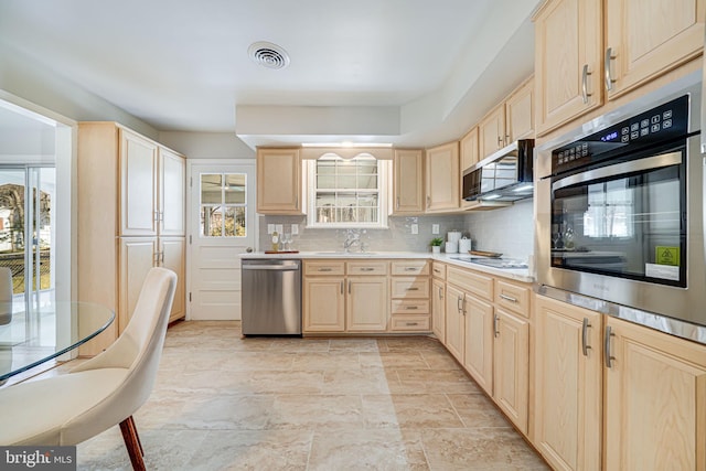 kitchen with stainless steel appliances, visible vents, light brown cabinets, and backsplash