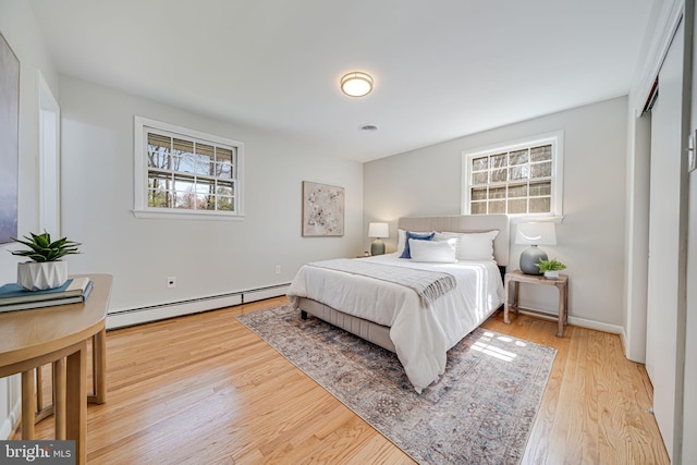 bedroom featuring light wood-style floors and baseboard heating
