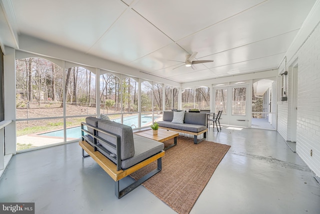 sunroom with finished concrete floors, outdoor lounge area, french doors, and ceiling fan