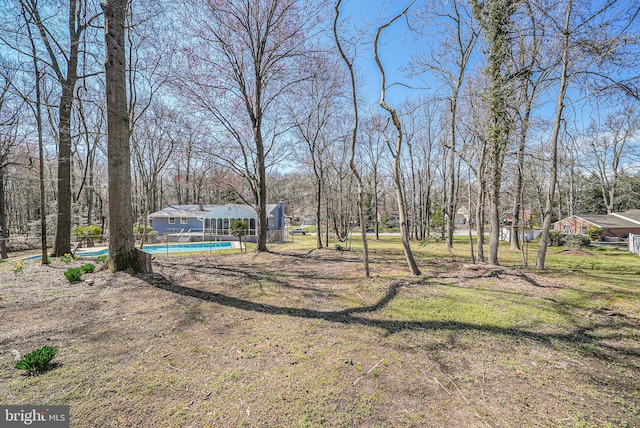 view of yard with an outdoor pool and an outbuilding
