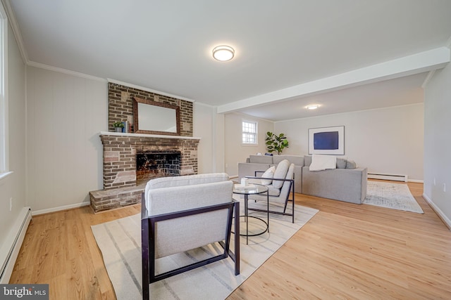 living area with baseboard heating, a baseboard heating unit, baseboards, a fireplace, and wood finished floors