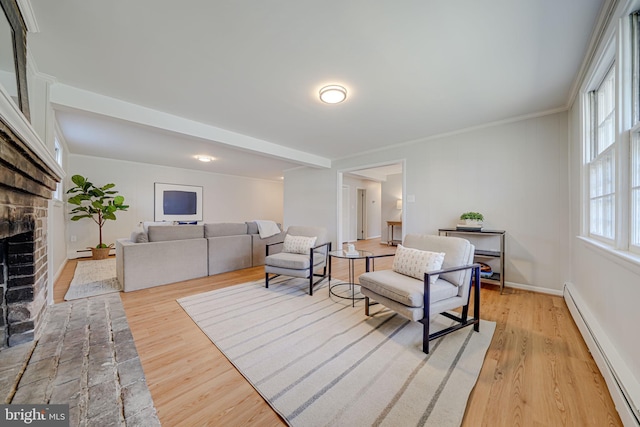 living area featuring baseboard heating, a fireplace, ornamental molding, and light wood-style flooring