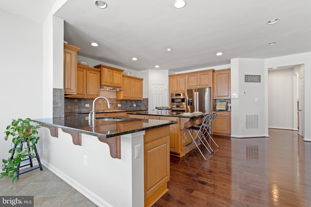 42364 Winsbury W Pl, Sterling, VA 20166 - kitchen featuring a breakfast bar area, a peninsula, a sink, recessed lighting, and stainless steel fridge with ice dispenser