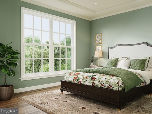 bedroom with crown molding, wood finished floors, and baseboards