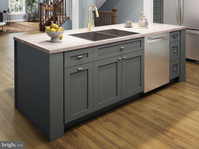 kitchen featuring dark wood-type flooring, appliances with stainless steel finishes, a sink, and gray cabinetry