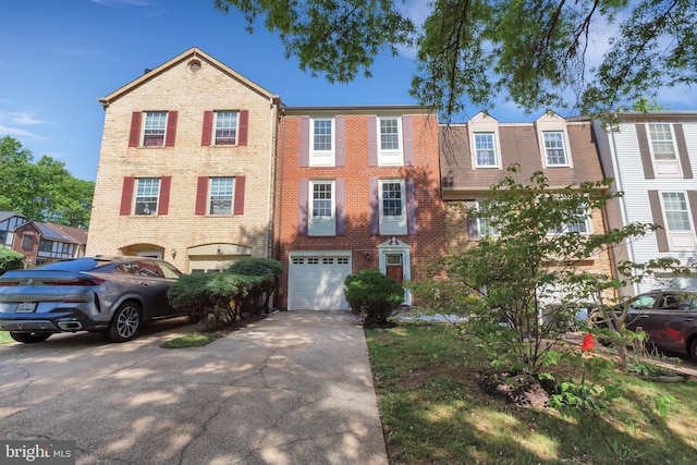 multi unit property featuring concrete driveway, brick siding, and a garage