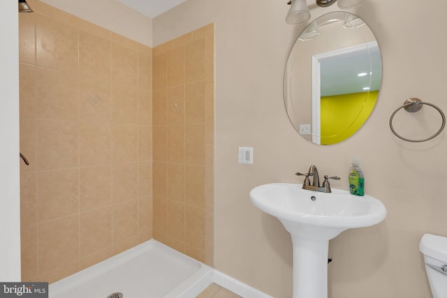 bathroom with a sink, a shower stall, and toilet