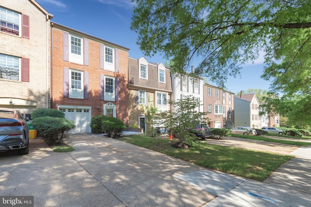 view of front of house featuring a residential view, driveway, brick siding, and a garage