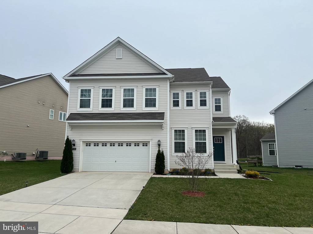traditional-style home featuring central air condition unit, an attached garage, concrete driveway, and a front yard