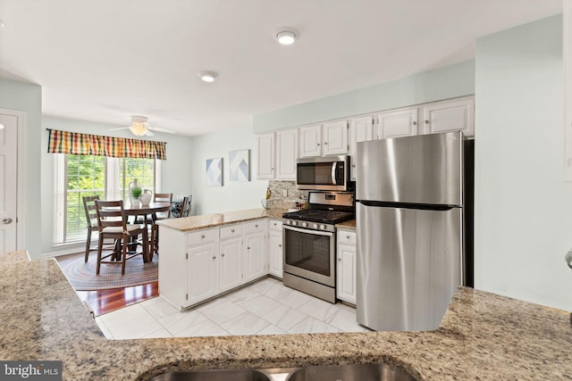 12015 Johns Pl, Fairfax, VA 22033 - kitchen with stainless steel appliances, a peninsula, white cabinets, and ceiling fan