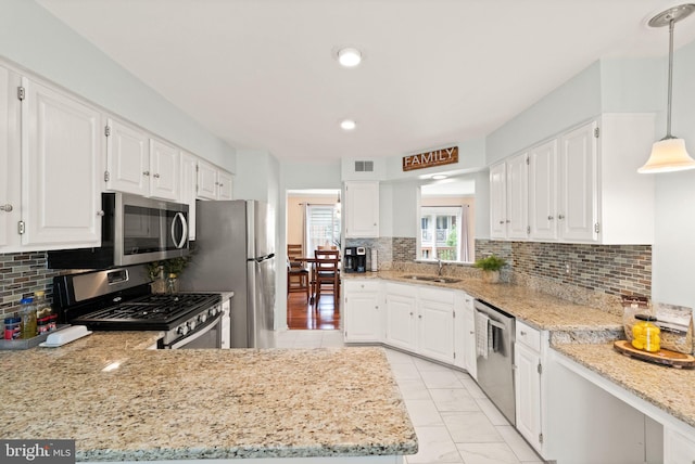 12015 Johns Pl, Fairfax, VA 22033 - kitchen featuring stainless steel appliances, white cabinets, a sink, tasteful backsplash, and light stone countertops