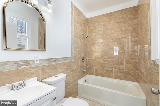 full bathroom featuring vanity, tile walls, toilet, and shower / washtub combination