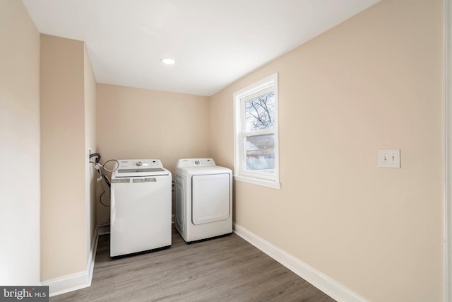 laundry room featuring washer and clothes dryer, light wood-style flooring, laundry area, and baseboards