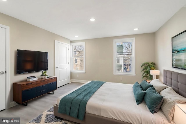 bedroom with light wood finished floors, baseboards, and recessed lighting
