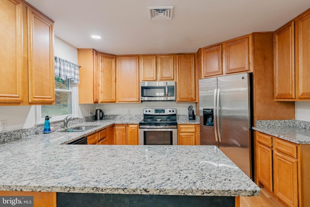 97 Winding Creek Rd, Stafford, VA 22554 - kitchen with appliances with stainless steel finishes, a sink, light stone counters, a peninsula, and recessed lighting