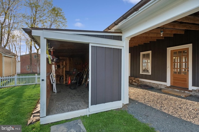 view of outdoor structure featuring fence and an outbuilding