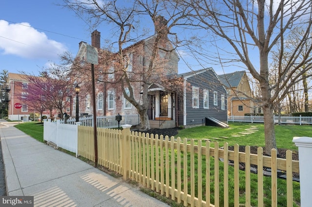 view of front of house featuring a fenced front yard and a front lawn