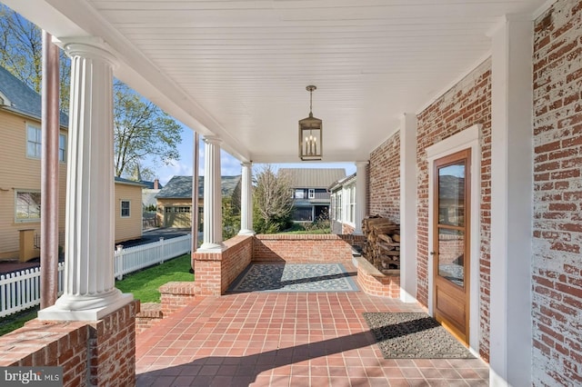 view of patio featuring a porch and fence