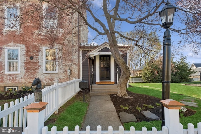 view of front of house with brick siding, a front lawn, and a fenced front yard