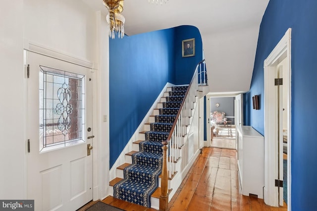 foyer with wood-type flooring, stairs, and a wealth of natural light