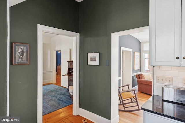hallway with baseboards and light wood-style flooring