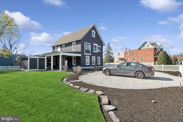 exterior space with fence, board and batten siding, and a lawn