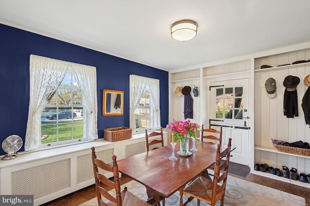 dining area with ornamental molding, radiator, and wood finished floors