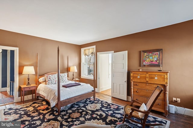 bedroom with baseboards and wood finished floors
