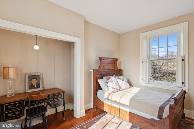 bedroom with baseboards and wood finished floors