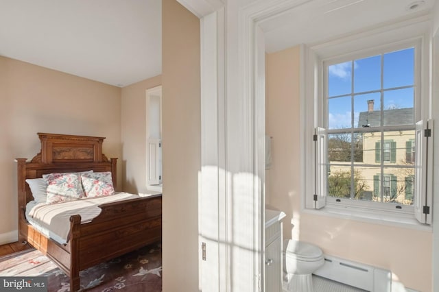 bedroom featuring multiple windows and baseboard heating