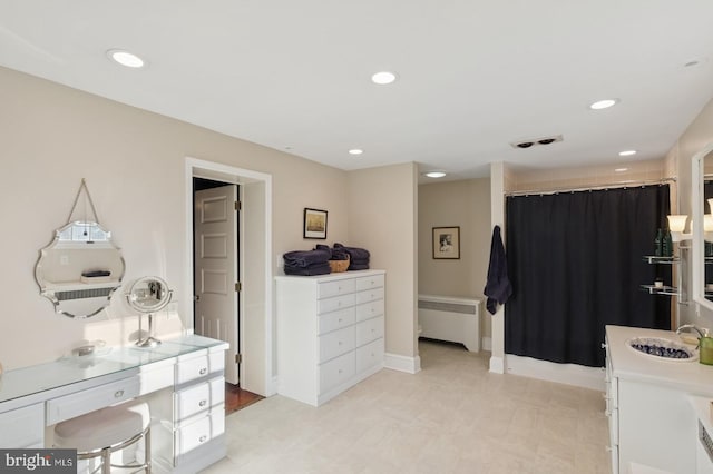 bedroom with a sink, radiator, baseboards, and recessed lighting