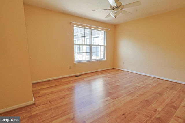 empty room with ceiling fan, visible vents, baseboards, and light wood-type flooring