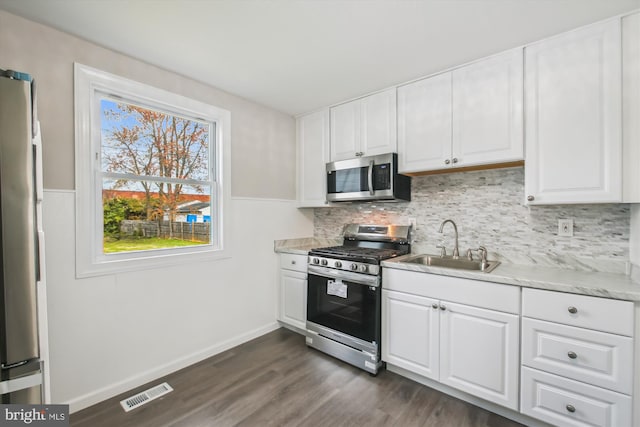 914 Andrews Rd, Glen Burnie, MD 21060 - kitchen featuring appliances with stainless steel finishes, a sink, white cabinetry, light countertops, and backsplash