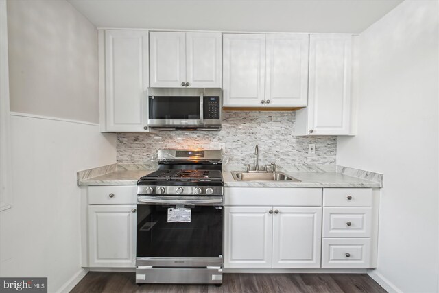 914 Andrews Rd, Glen Burnie, MD 21060 - kitchen with appliances with stainless steel finishes, a sink, light countertops, white cabinets, and tasteful backsplash