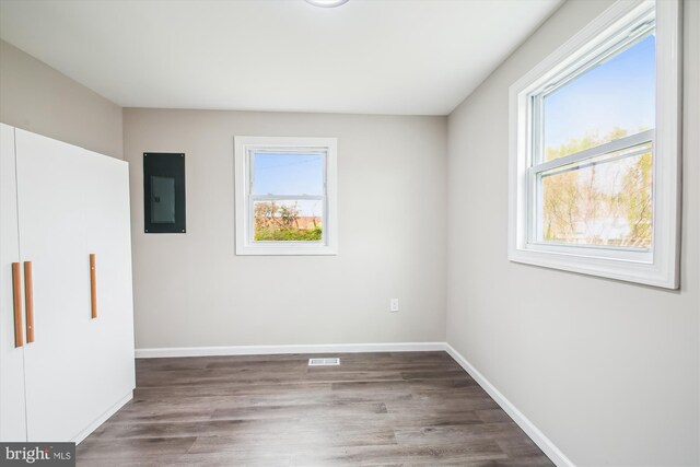914 Andrews Rd, Glen Burnie, MD 21060 - unfurnished bedroom with electric panel, multiple windows, and wood finished floors