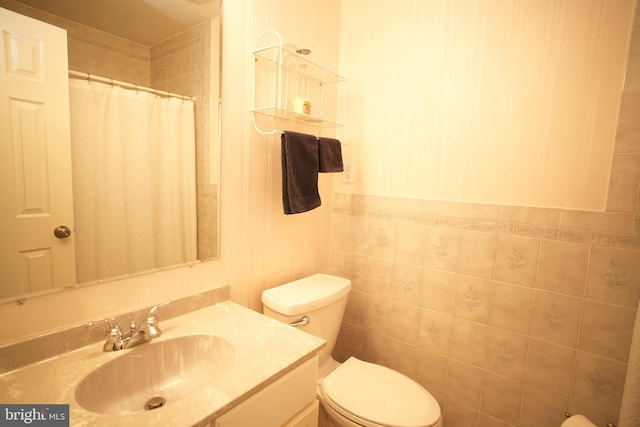 full bath with curtained shower, vanity, and toilet