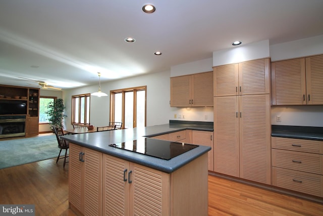 kitchen with dark countertops, black electric cooktop, light wood-type flooring, recessed lighting, and a peninsula
