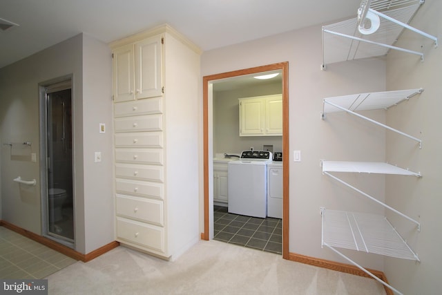laundry area featuring cabinet space, washer and dryer, baseboards, and light carpet