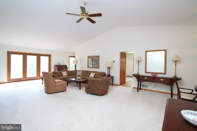 living area featuring light carpet, ceiling fan, high vaulted ceiling, and baseboards