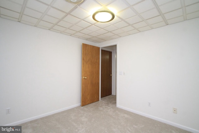 carpeted empty room featuring baseboards