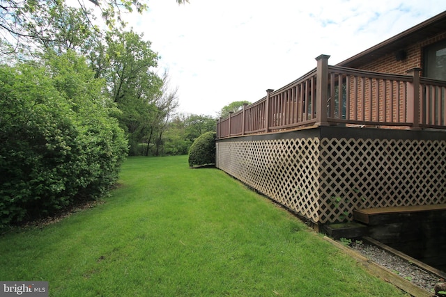 view of grassy yard with a deck