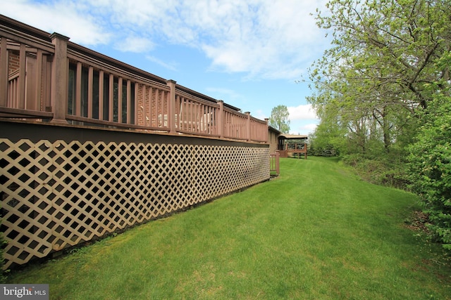 view of grassy yard featuring a wooden deck