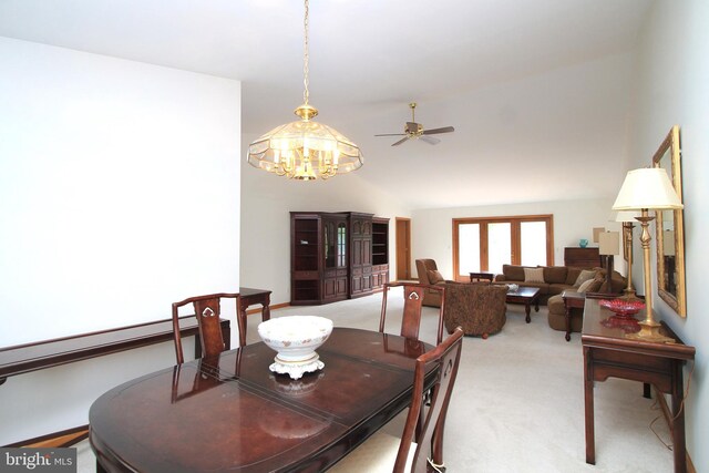 dining room with light colored carpet, lofted ceiling, a ceiling fan, and a chandelier