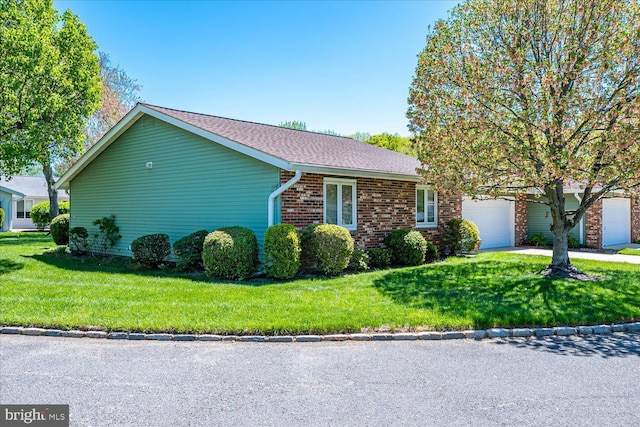 view of property exterior featuring a lawn, an attached garage, brick siding, and concrete driveway