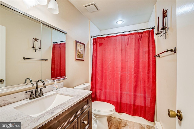 bathroom featuring visible vents, wood finished floors, toilet, and vanity