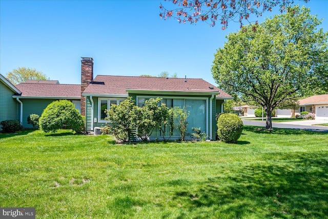 back of property with a lawn, a chimney, and cooling unit