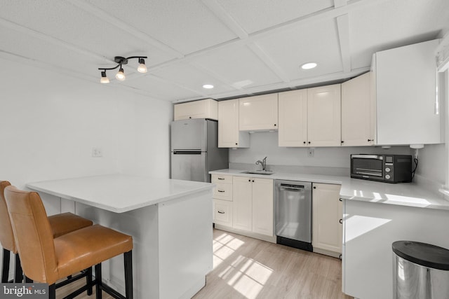 kitchen featuring a breakfast bar, stainless steel appliances, white cabinets, a peninsula, and recessed lighting