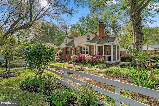 back of house with brick siding, a sunroom, a shingled roof, and a chimney