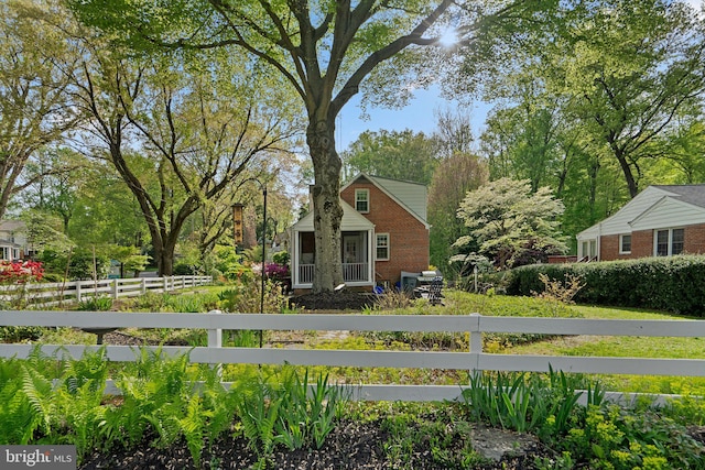 view of side of home with brick siding and fence