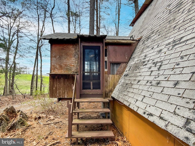 entrance to property with roof with shingles